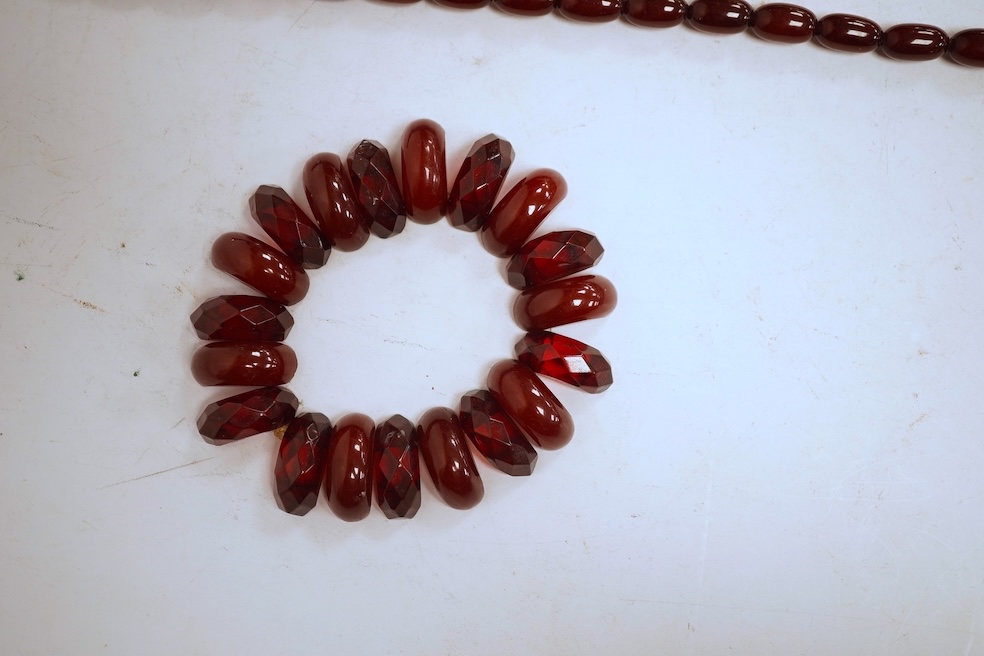 A single strand graduated oval simulated amber bead necklace, 72cm, gross weight 64 grams, together with a simulated cherry amber bracelet.